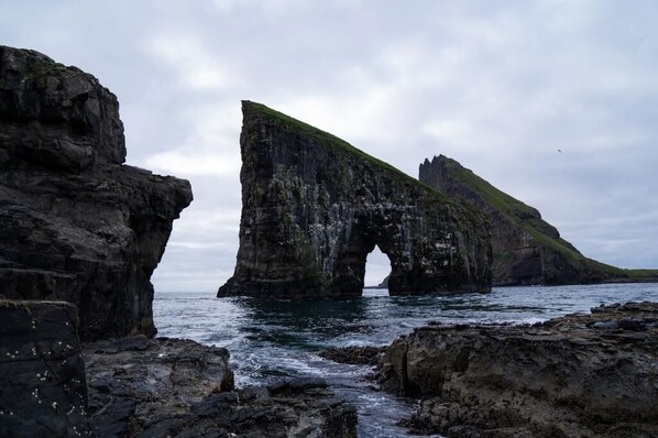 A coastal rock formation with a natural arch.