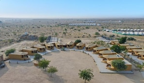 Una località turistica nel deserto con capanne circolari disposte attorno a un cortile centrale.