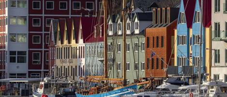 A harbor with colorful buildings and a large blue boat docked.