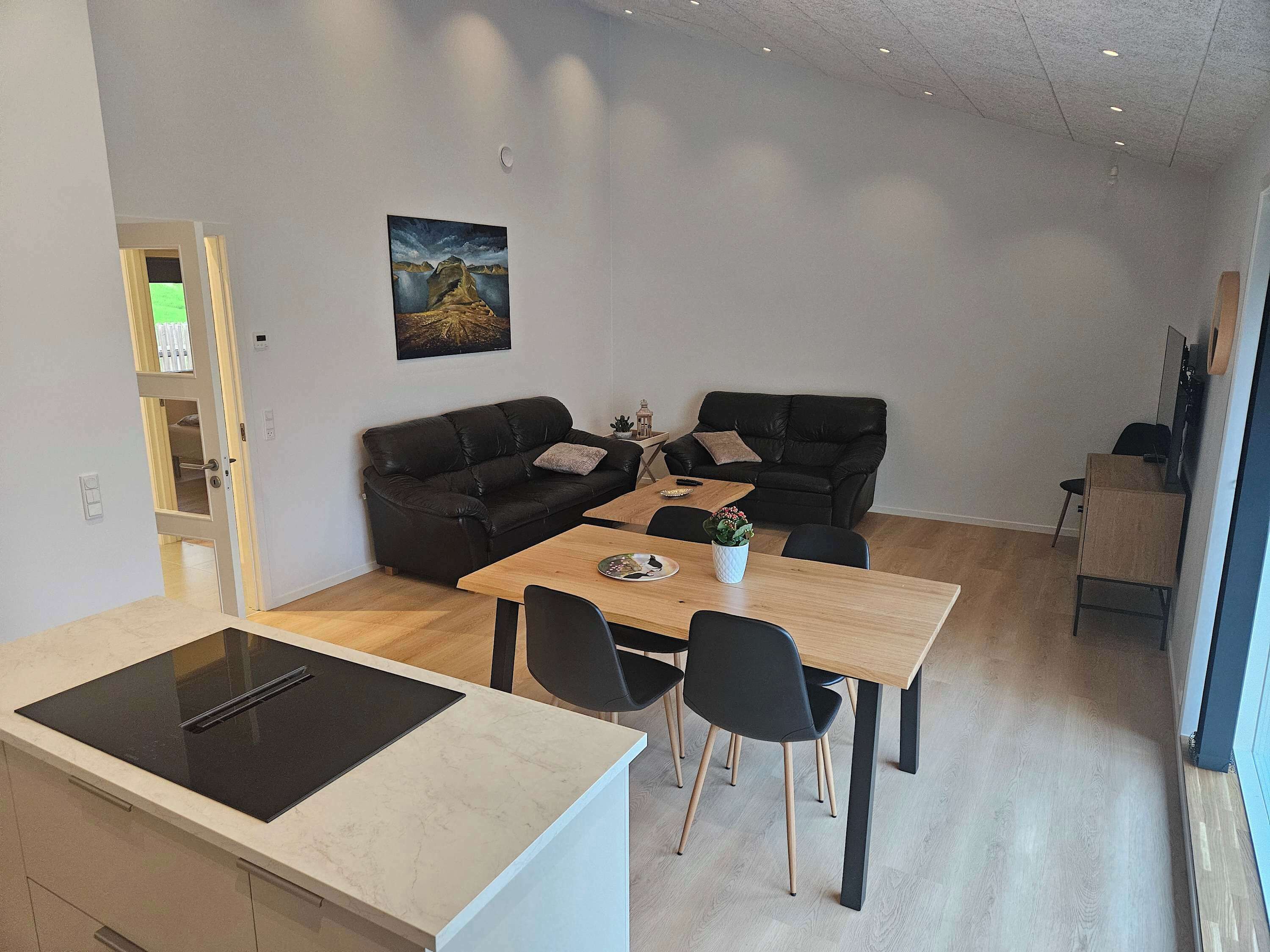 En kompakt bolig med tekøkken, spiseplads og siddeområde.