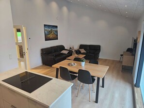 A compact living space with a kitchenette, dining area, and seating.