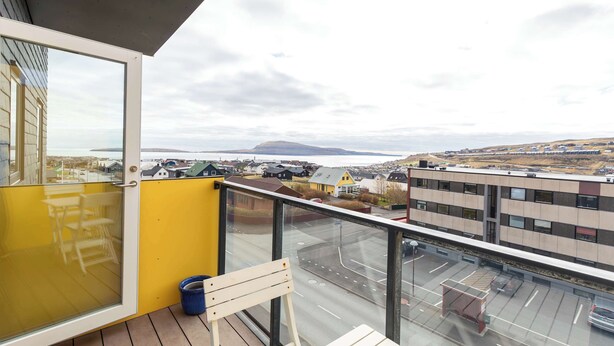 En balkong med utsikt över ett bostadsområde och en vattenyta.