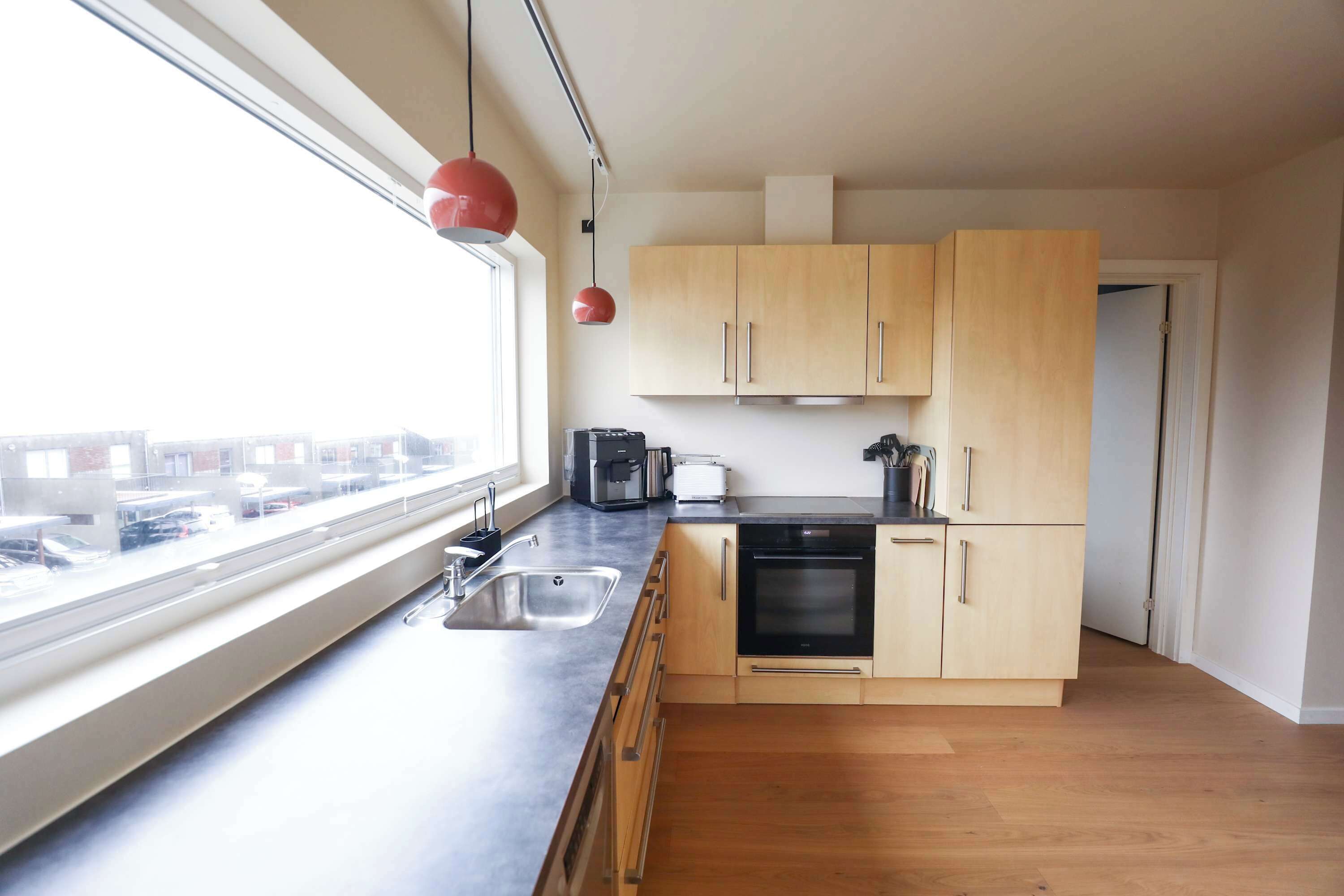 Een koffiezetapparaat/waterkoker, een koelkast, een oven, een kookplaat