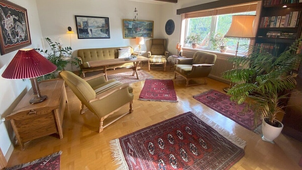 A cozy living room with a sofa, armchairs, a coffee table, and a fireplace.