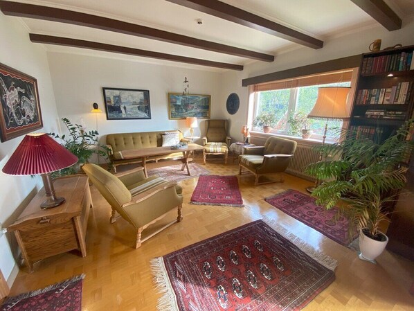 A cozy living room with a sofa, armchairs, a coffee table, and a fireplace. - 5BR Charming Villa with Stunning Views - 9 guests (Vestmanna)