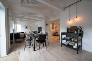 Een moderne woonruimte met een eethoek, keuken en zithoek.