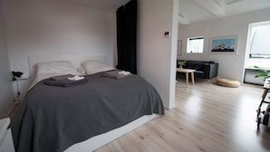 Una camera da letto moderna con un letto grande, un comodino, una lampada e un lampadario.