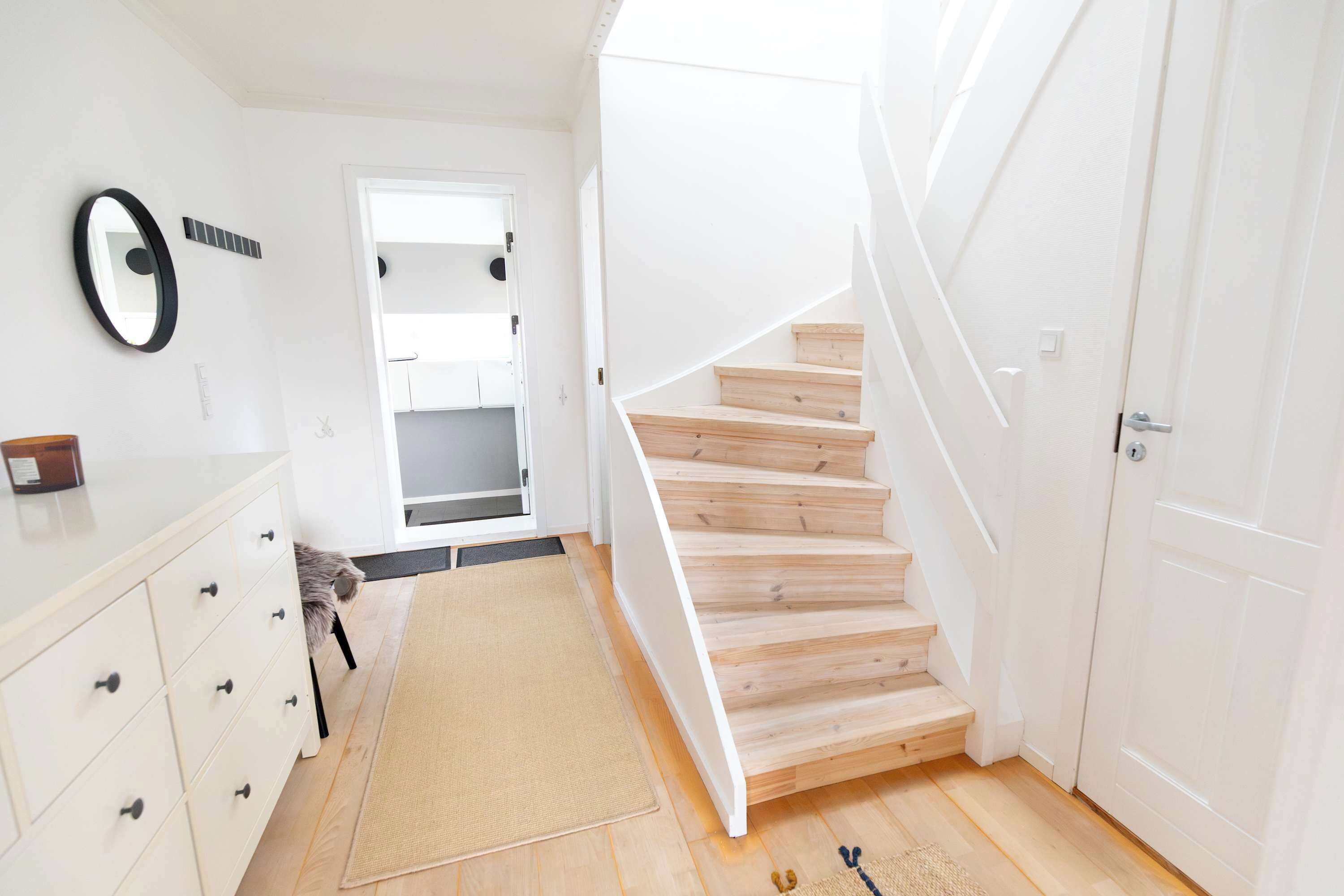 Eine Treppe führt zu einer zweiten Etage, am Ende befindet sich eine weiße Tür.