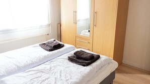 A bedroom with a single bed, a wardrobe, and a mirror. - Cozy Apartment in the Heart of Torshavn - 6 Sleeps (Tórshavn)