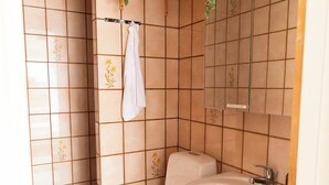 A small bathroom with a toilet, sink, and a towel rack with a hanging plant. - Cozy Apartment in the Heart of Torshavn - 6 Sleeps (Tórshavn)
