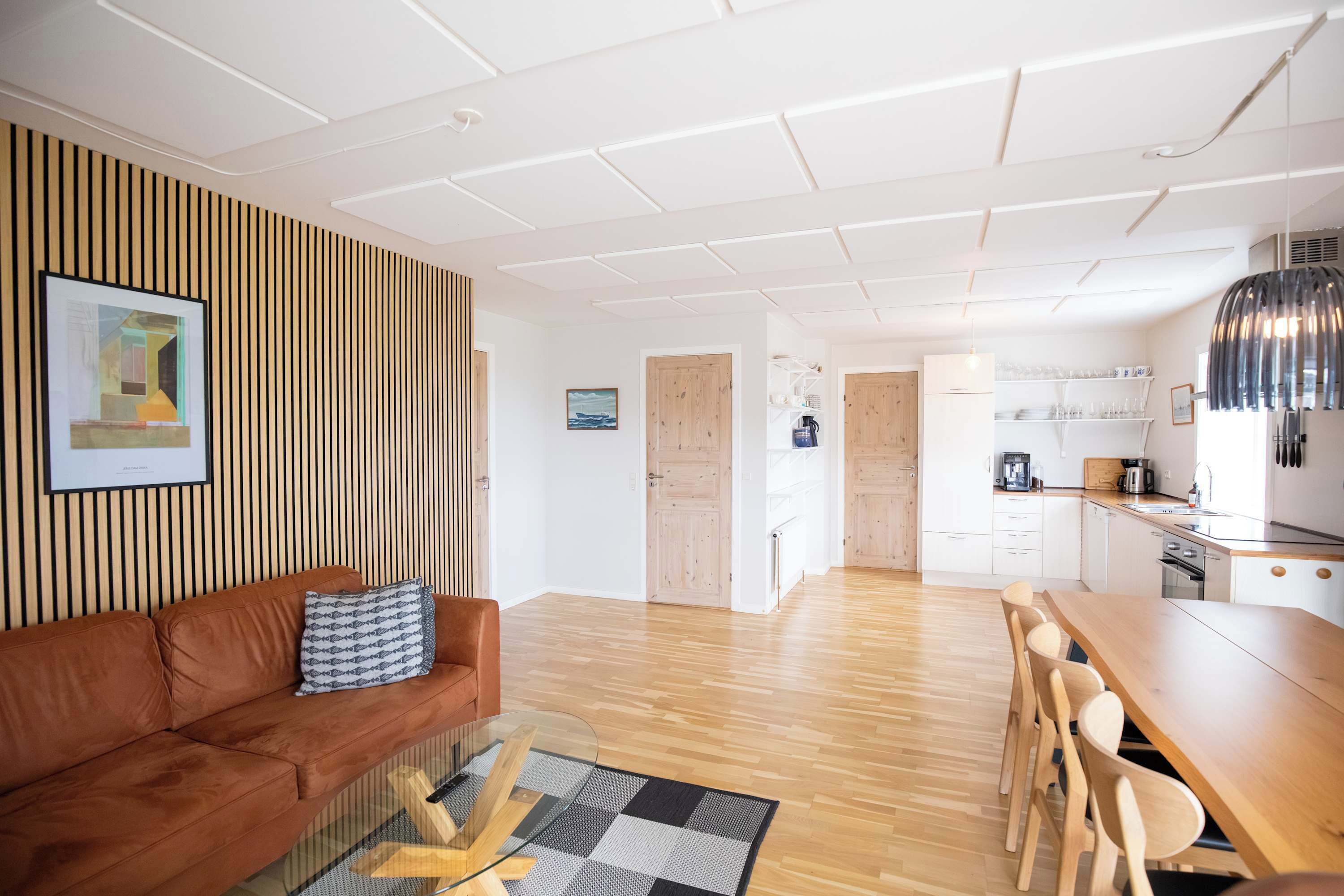 En moderne stue med en brun sofa, et glasbord og en trægulv.