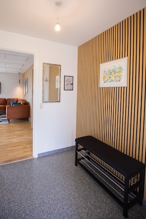 A modern interior with a bench, a framed artwork, and a mirror on the wall. - Torshavn Home with Views Near City Center (Tórshavn)