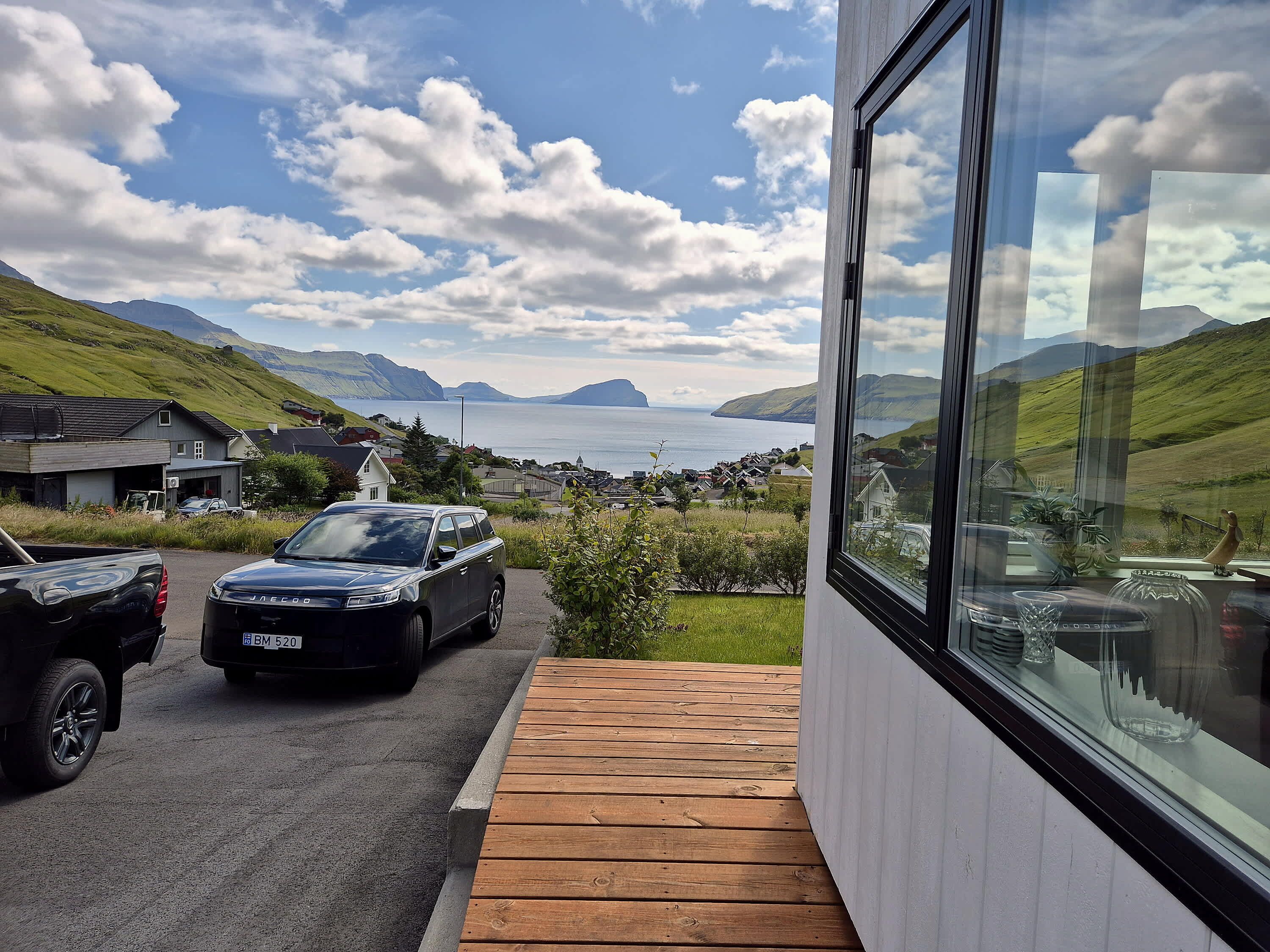 A modern building with a view of a coastal landscape, including a body of water and distant mountains.