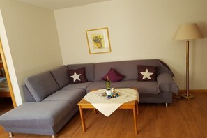 A living room with a grey sofa, a small table with a vase, and a lamp. - House at Gutach No. 6 (Titisee-Neustadt)