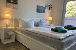 Un dormitorio con una cama, dos mesitas de noche y una obra de arte en la pared.
