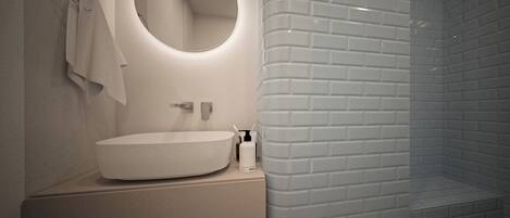 A modern bathroom with a round mirror, a sink, and a shower area.