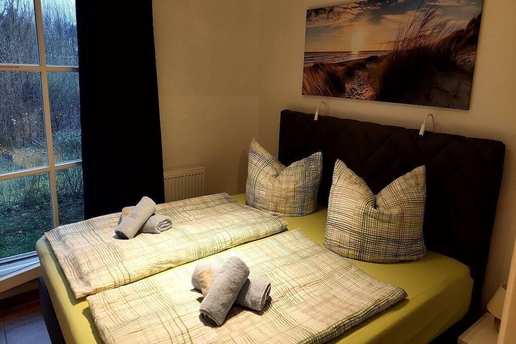 Ein Doppelbett mit Kopfstütze, zwei Kissen und einer Decke.