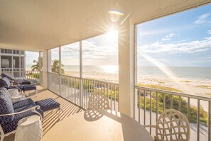 A balcony with a view of the beach, furnished with chairs and a table. - Beachfront 2B/2B Vacation Condo at Creciente w/Million $$$ View! (Fort Myers Beach)