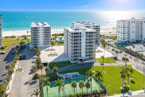 A beachfront hotel with multiple high-rise buildings, a parking lot, and a tennis court. - Beachfront 2B/2B Vacation Condo at Creciente w/Million $$$ View! (Fort Myers Beach)