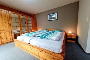 Un dormitorio con una cama de madera, una mesita de noche y un armario.