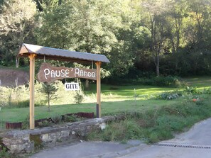 A wooden sign with the text 'Pause Rando' and 'GITE' indicating a rest area or campsite.