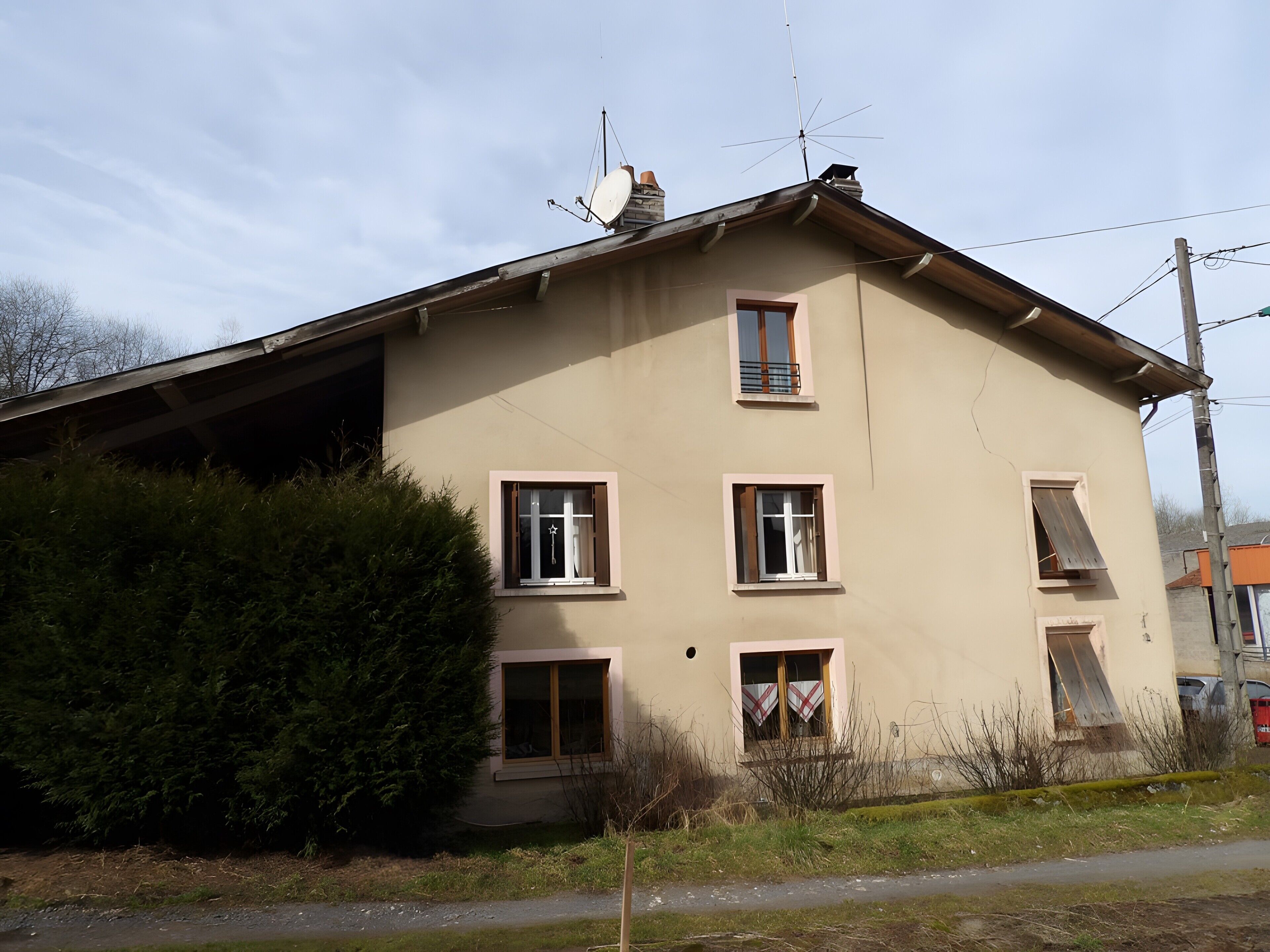 A two-story building with multiple windows and a satellite dish on the roof.