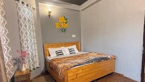A bedroom with a wooden bed, a ceiling fan, and a wall-mounted light fixture.