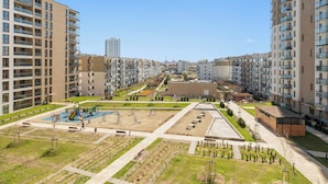 A residential area with modern apartment buildings, a playground, and a landscaped park.