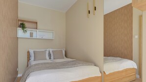 Un dormitorio con cama, mesitas de noche, un espejo y una estantería decorada con objetos.