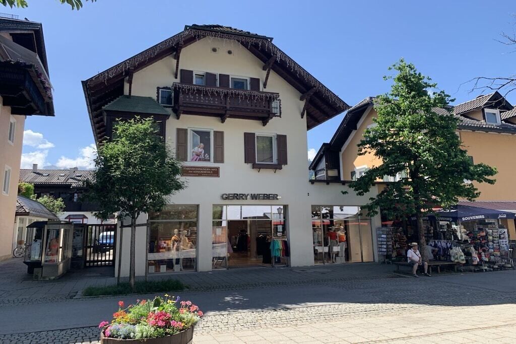 A building with a sign 'GERRY WEBER' and a shop with mannequins.