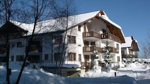 Um hotel com vários andares, varandas e um telhado coberto de neve.