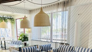 Una sala moderna con sofás a rayas, una mesa de centro de vidrio y una pared decorativa de madera.