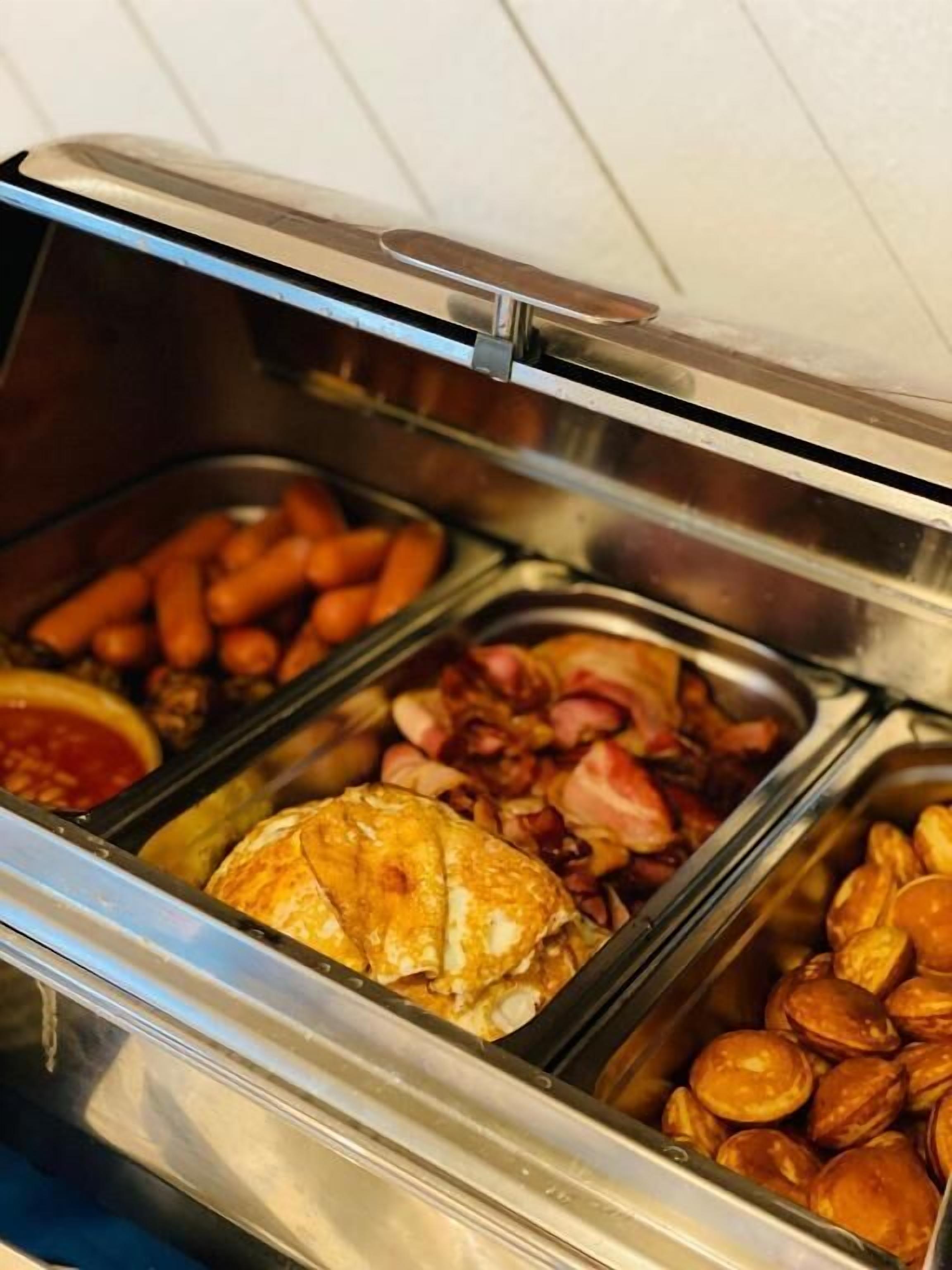 Ein reichhaltiges Buffet mit Wurstwaren, einem Auflauf und Bratkartoffeln.