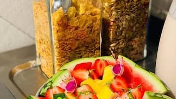 Bandeja de café da manhã com melancia fatiada e diversos cereais em potes de vidro.