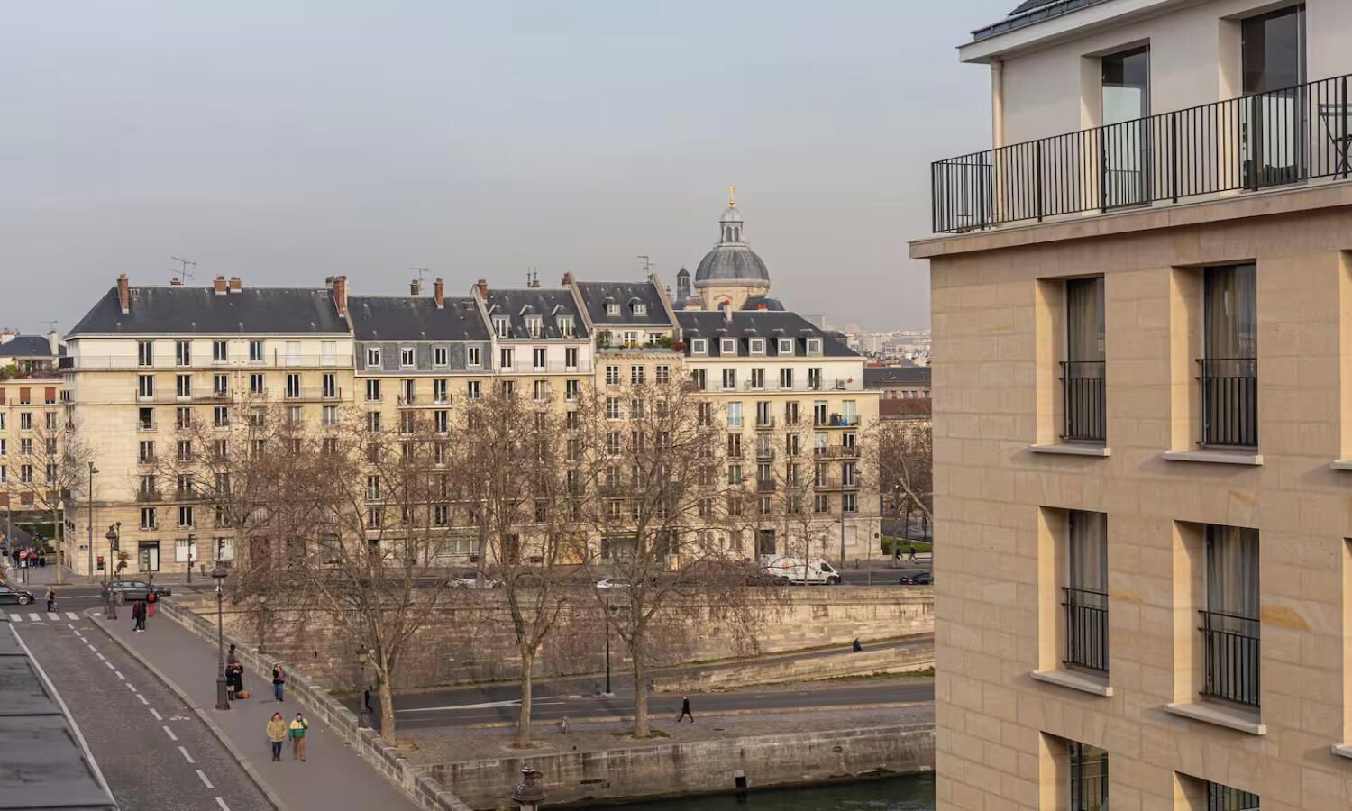 A row of historic buildings with a river in the foreground.