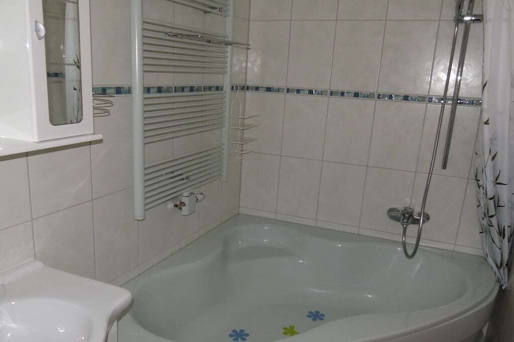 Ein Badezimmer mit Badewanne, Toilette und Duschbereich.