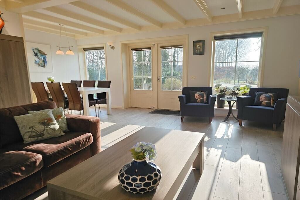 Un vaste espace de vie comprenant une table basse en bois, deux canapés et une table à manger avec des chaises.