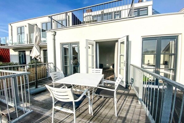 A modern building with a balcony featuring a table and chairs. - DO06 Holiday home Domburg (Domburg)