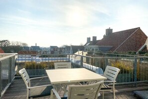 A rooftop terrace with a table and chairs, a view of the city, and a railing. - DO06 Holiday home Domburg (Domburg)