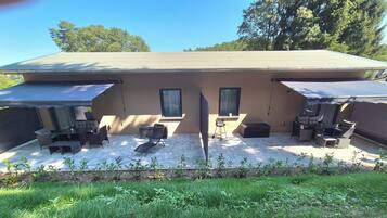 Ein überdachter Patio-Bereich mit Gartenmöbeln und einem kleinen Garten.