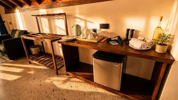 Una cocina funcional con una mesa de madera, un lavamanos y un refrigerador pequeño.