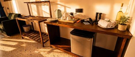 A compact kitchen with a wooden table, a sink, and a compact refrigerator.
