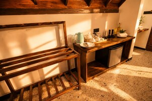 Een keuken met een houten bankje, een aanrecht met keukengerei en een vaatwasser.