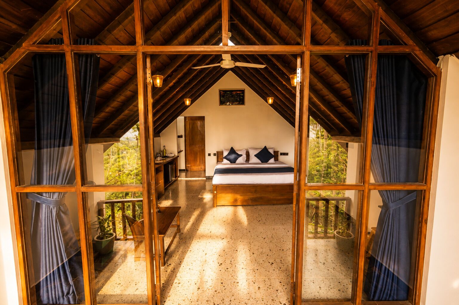 Un dormitorio con cama, ventilador de techo y vistas al exterior.
