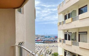 Un balcón con vista a un puerto deportivo y una playa.