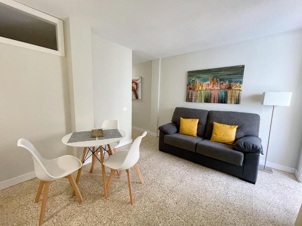 Una sala de estar con un sofá, dos sillones, una mesita y un cuadro en la pared.