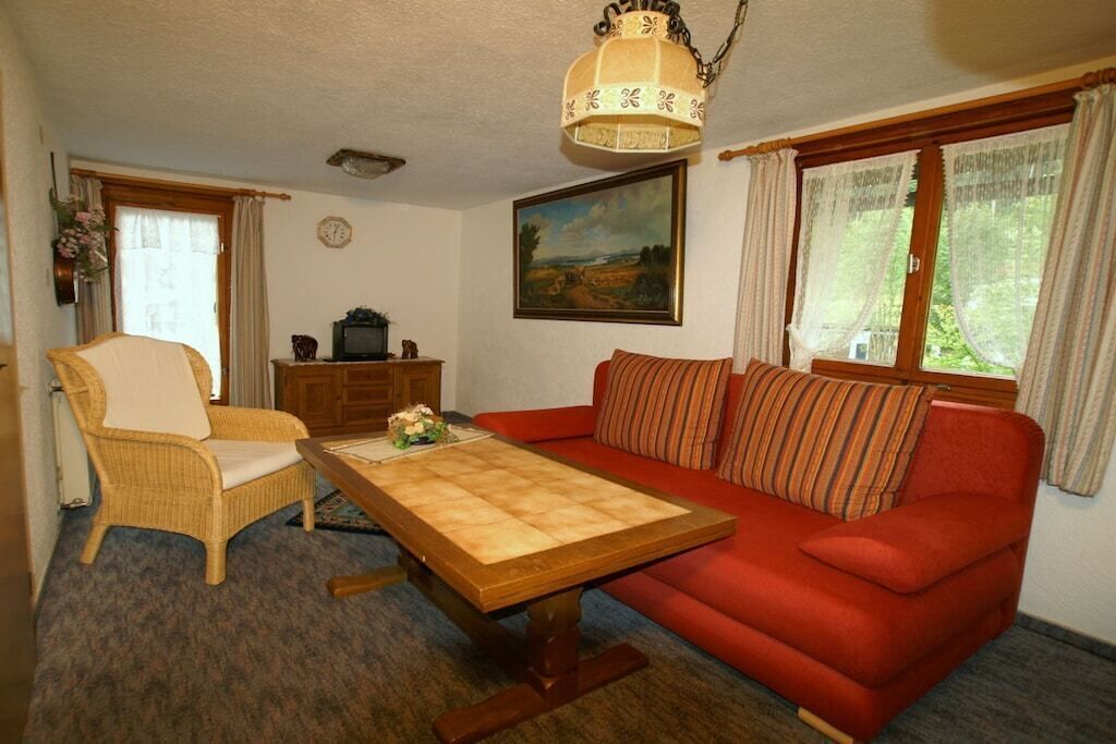 A living room with a sofa, armchair, and a wooden coffee table.