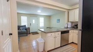 A compact kitchen with a dishwasher, a coffee maker, and a refrigerator. - 2BR Ground Floor, Sleeps 8, Pets ok - SPI (South Padre Island)