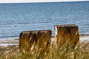 Zwei Korbflechte Körbe mit Nummern, auf einem Strand mit Blick auf das Meer.