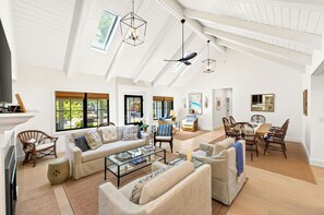 A spacious living room with high ceilings, large windows, and a dining area with wooden chairs. - Private In-Town Retreat (St Helena)